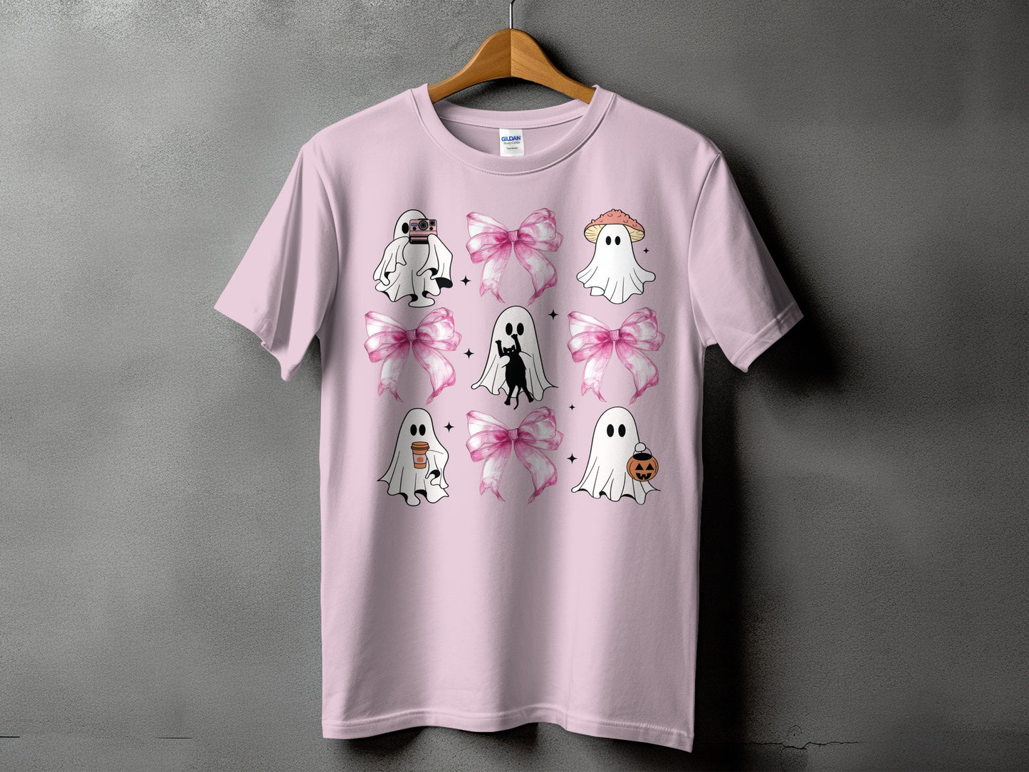Pink t-shirt with Halloween-themed ghost graphics and pink bows.