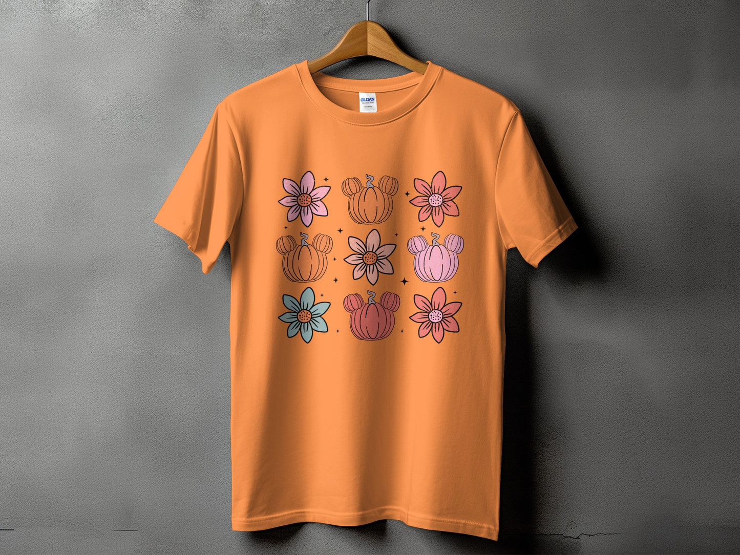Orange t-shirt with a grid of pastel flowers and Mickey-shaped pumpkins.