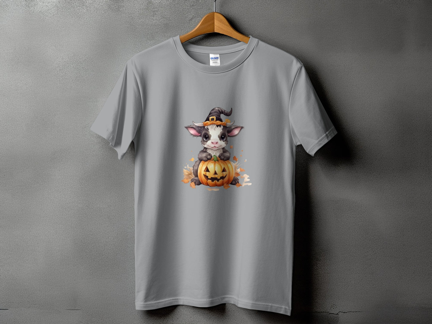 Gray t-shirt with a cute cow wearing a witch hat on a pumpkin.