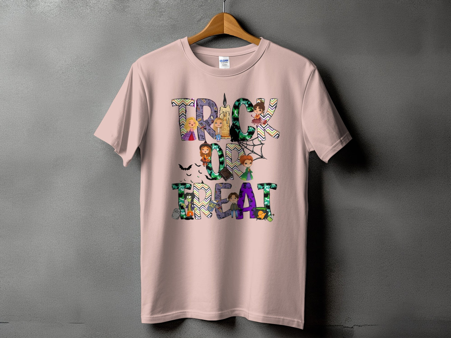 Pink t-shirt with "Trick or Treat" Halloween graphic featuring cartoon witches and spooky elements.