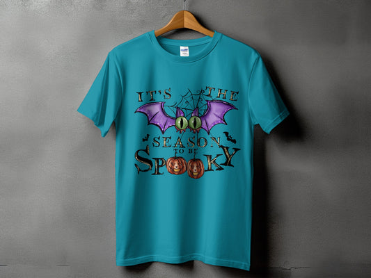 Teal t-shirt with "It's The Season To Be Spooky" Halloween graphic.