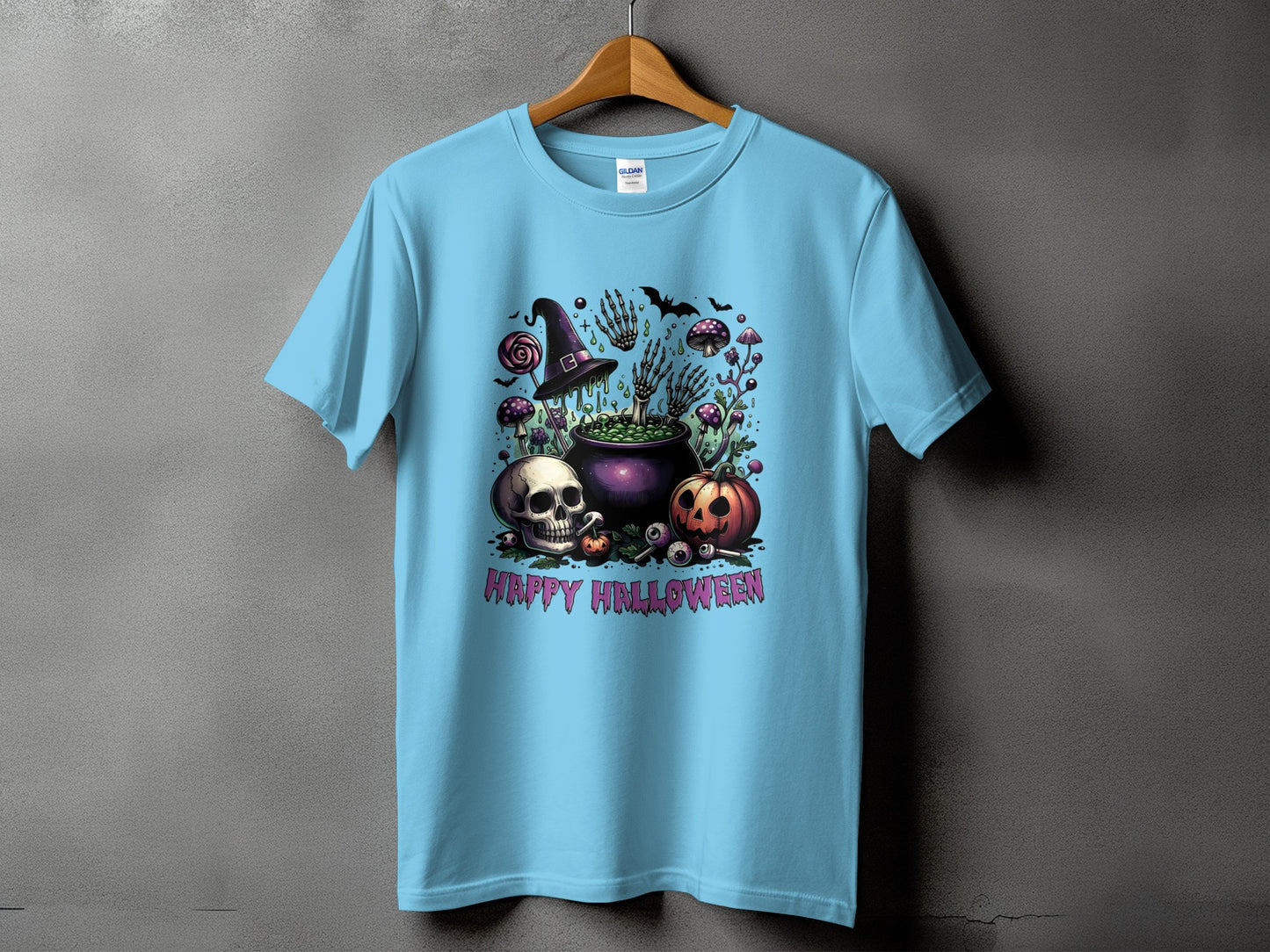 Light blue t-shirt with Halloween graphic featuring skull, pumpkin, cauldron, and text.