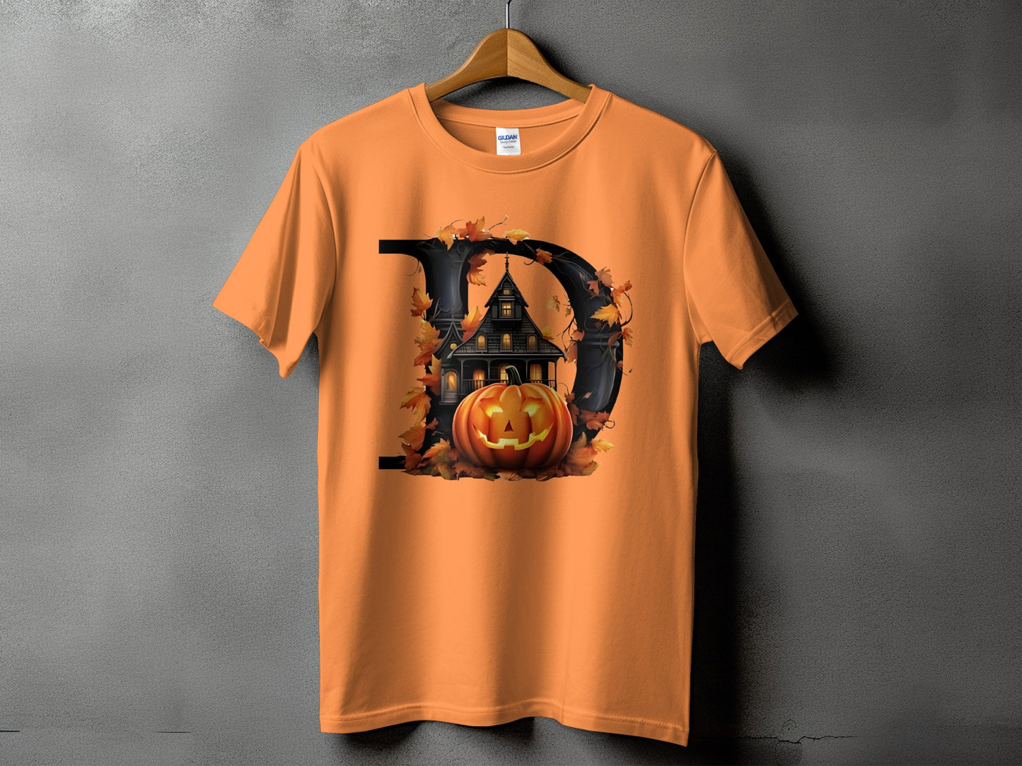 Orange t-shirt with a large black "D" graphic featuring a haunted house and pumpkin.