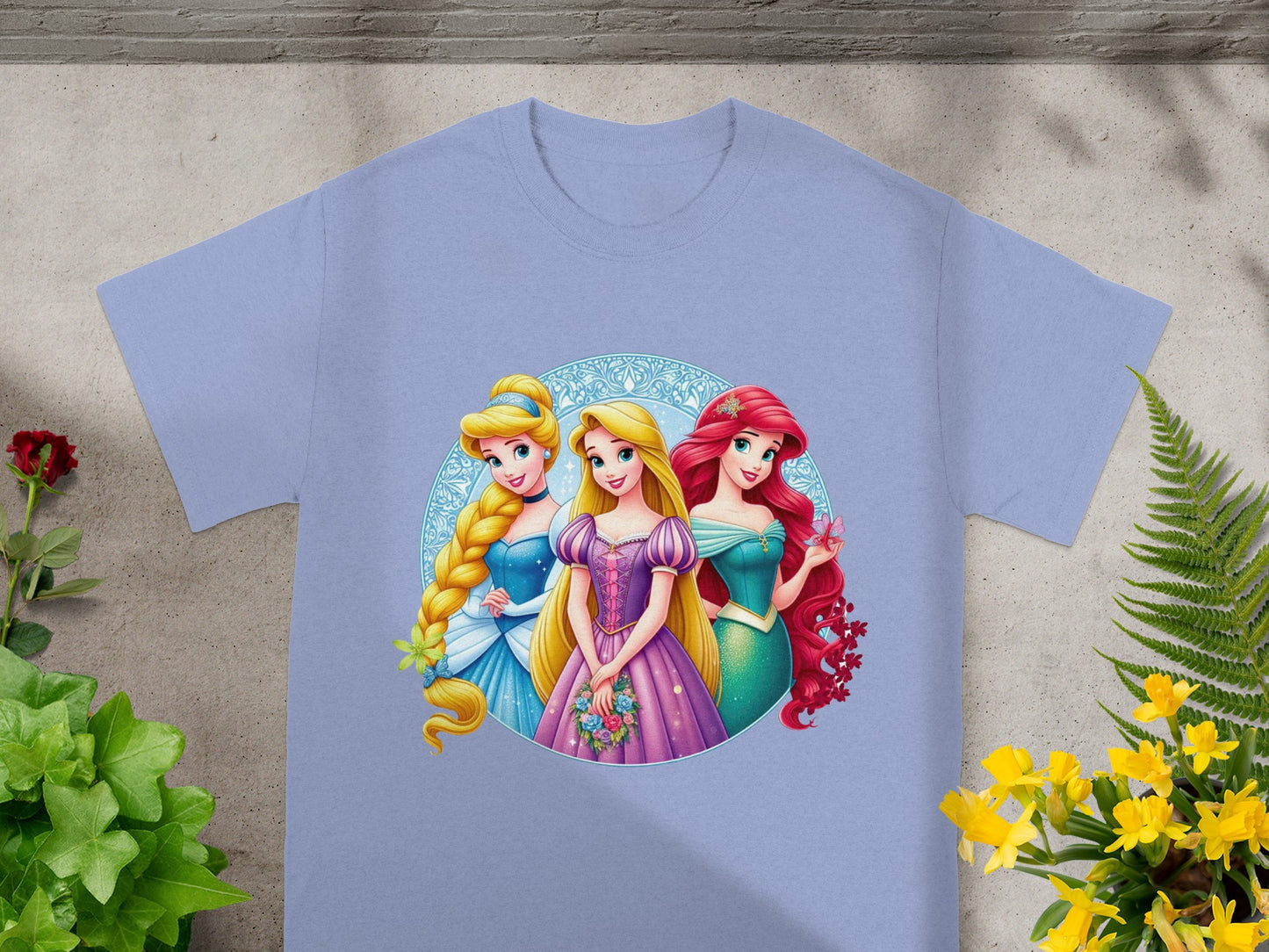 Disney Princesses Rapunzel, Cinderella, and Ariel graphic on a light purple t-shirt.