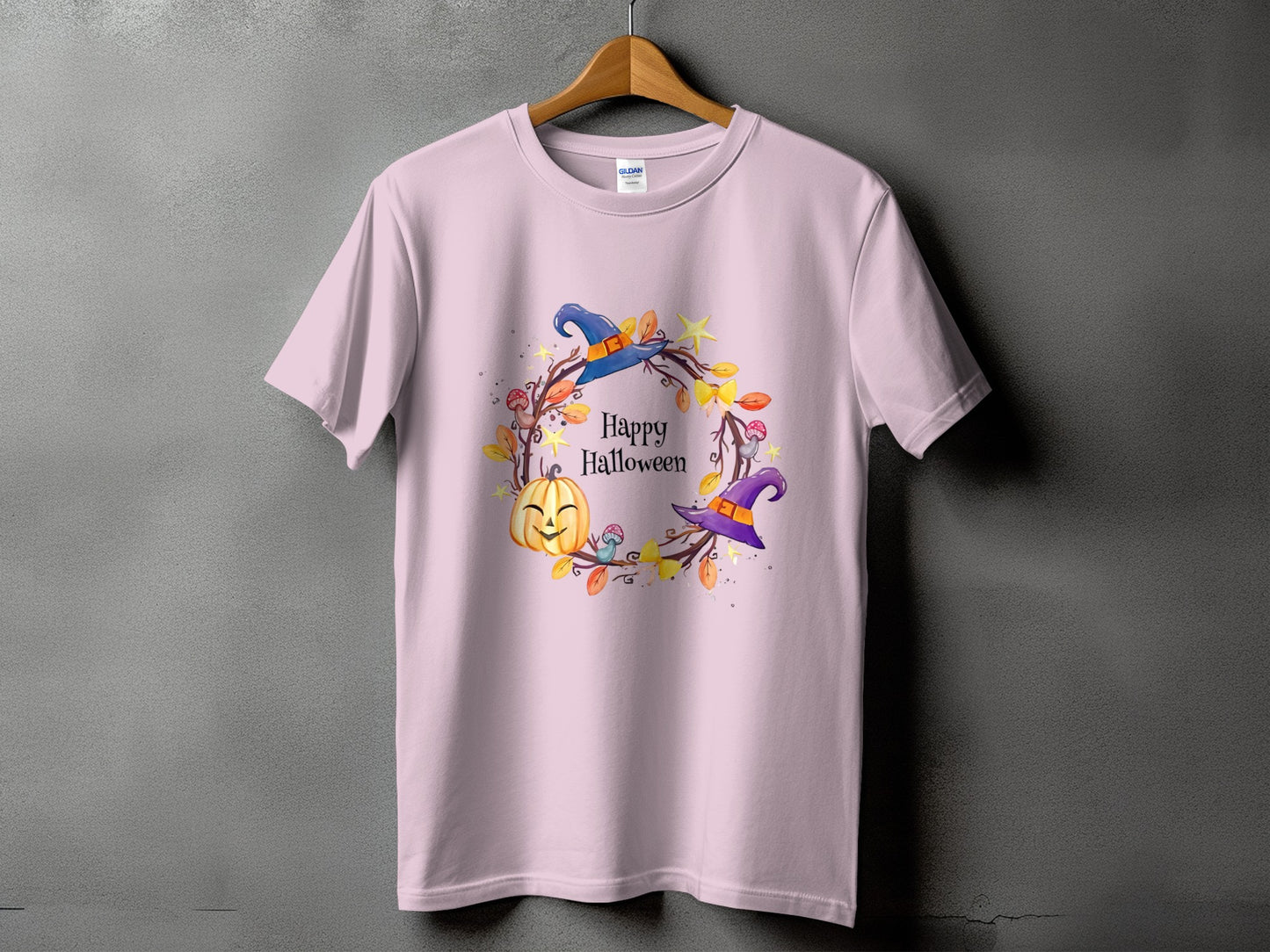 Pink t-shirt with a "Happy Halloween" wreath featuring a pumpkin and witch hats.