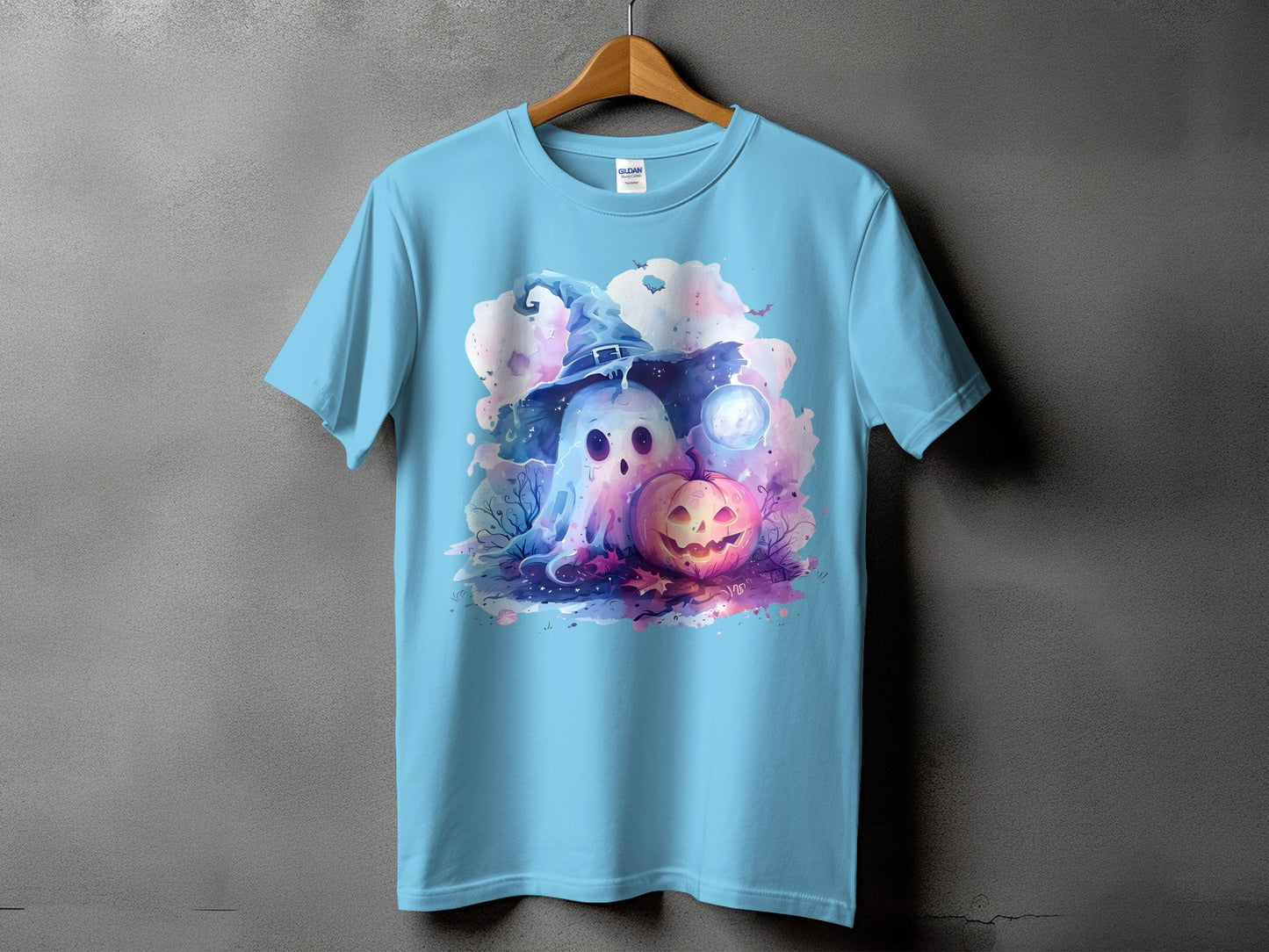 Light blue t-shirt with watercolor graphic of a ghost in a witch hat and a jack-o'-lantern.