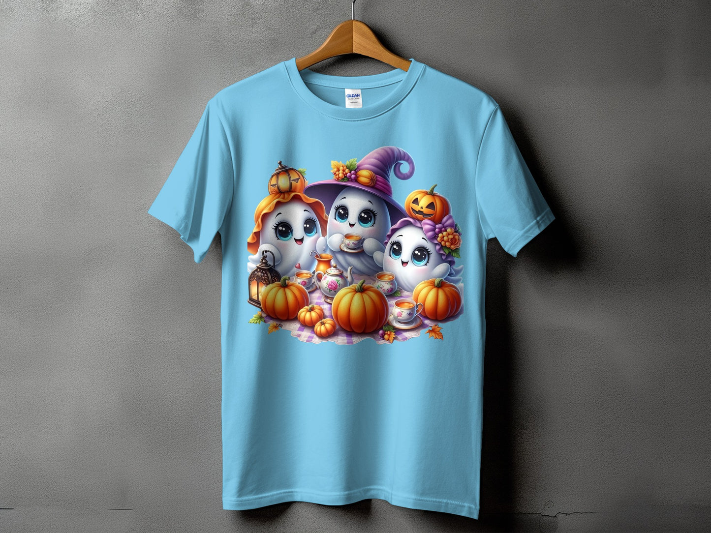 Three cute ghosts with pumpkins and a tea set on a light blue t-shirt.