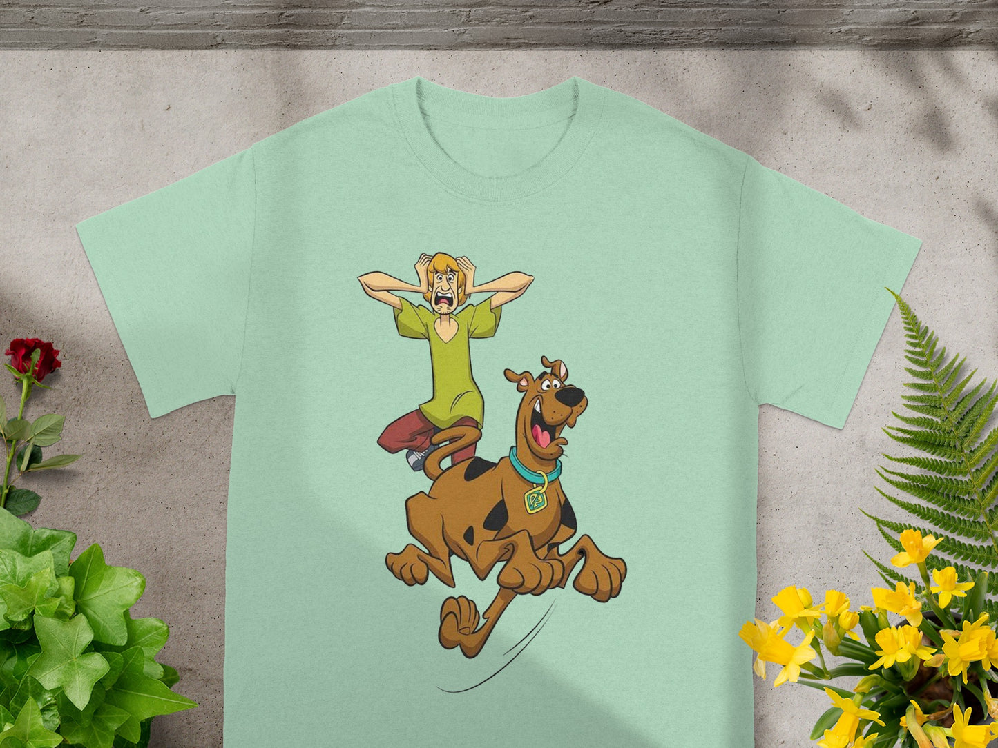 Scooby-Doo and Shaggy running, printed on a light green t-shirt.