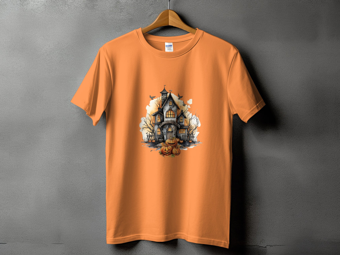 Orange t-shirt with a spooky haunted house and pumpkins Halloween graphic.