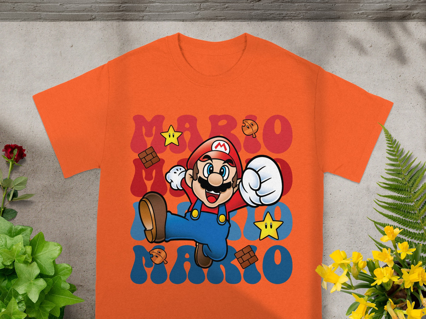 Orange t-shirt with cartoon Mario jumping and the word "MARIO" in blocks.