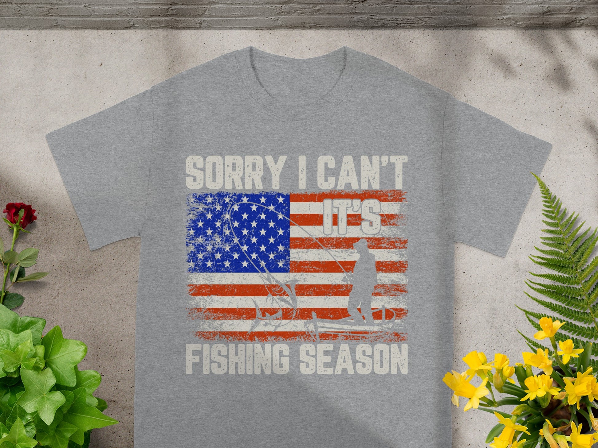 Grey t-shirt with "Sorry I Can't It's Fishing Season" text and distressed US flag graphic.