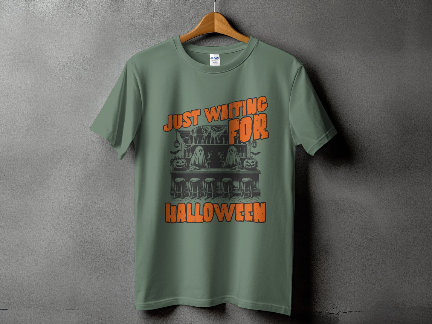 Green t-shirt with "Just Waiting For Halloween" text and a Halloween-themed bar scene graphic.