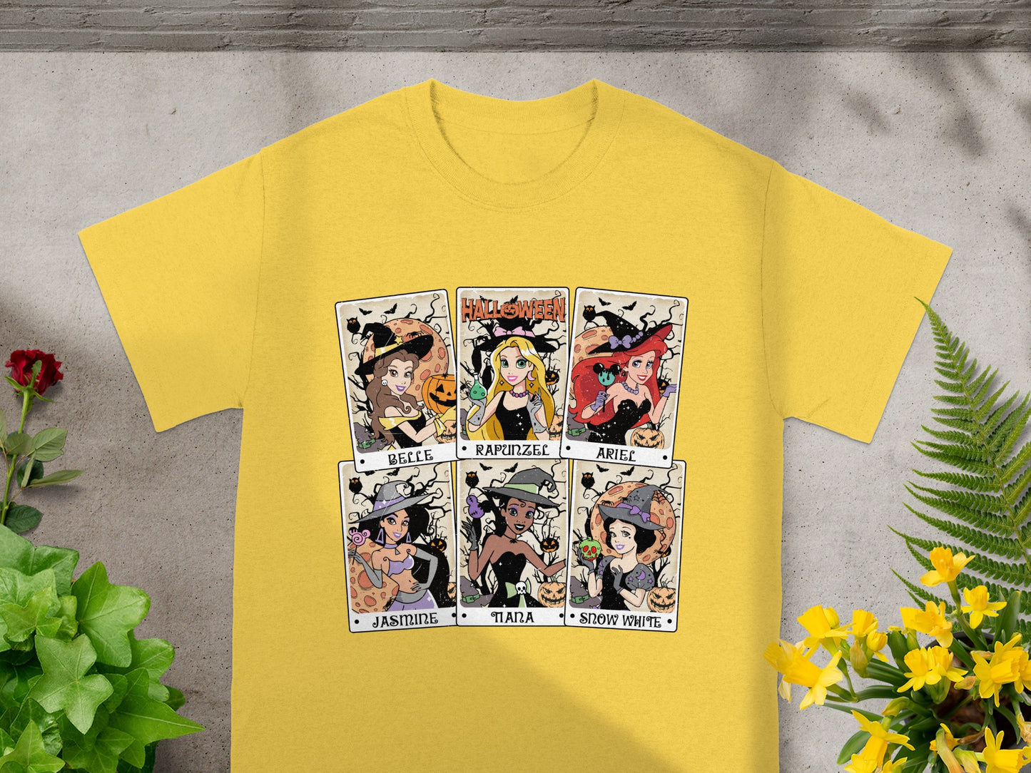 Yellow t-shirt with six Halloween-themed princess character cards: Belle, Rapunzel, Ariel, Jasmine, Tiana, and Snow White.