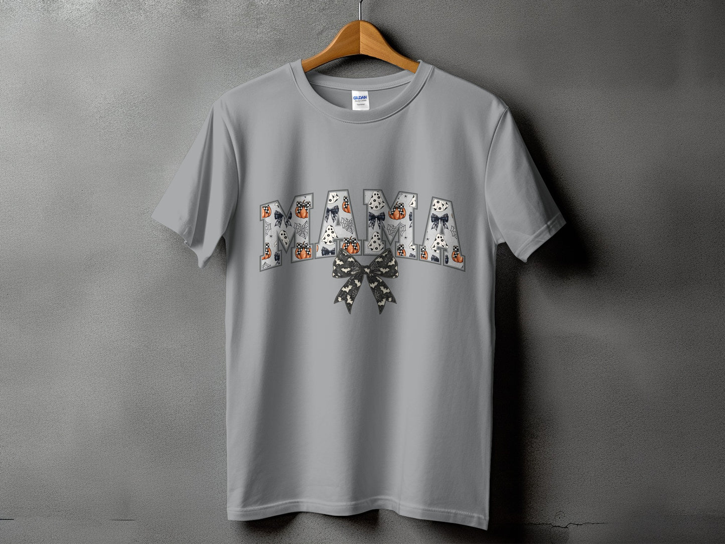 Grey t-shirt with "Mama" in block letters filled with Halloween patterns and a bow.