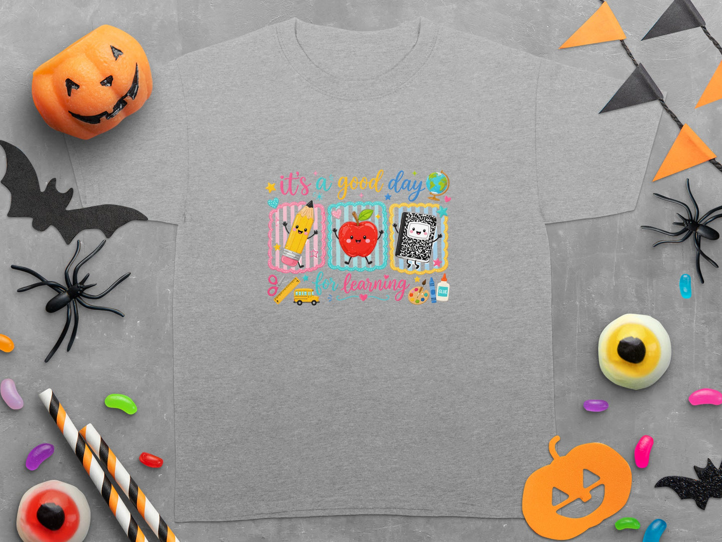 Gray t-shirt with "it's a good day for learning" graphic and Halloween decorations.