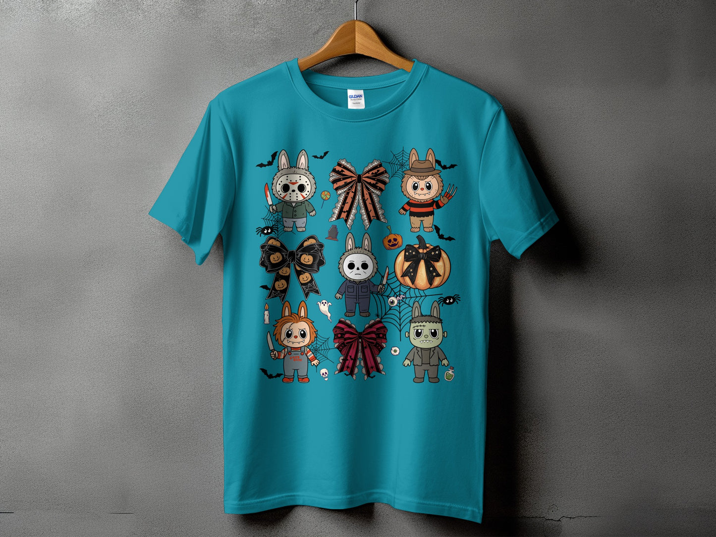 Teal t-shirt with a collage of cute Halloween horror characters and bows.