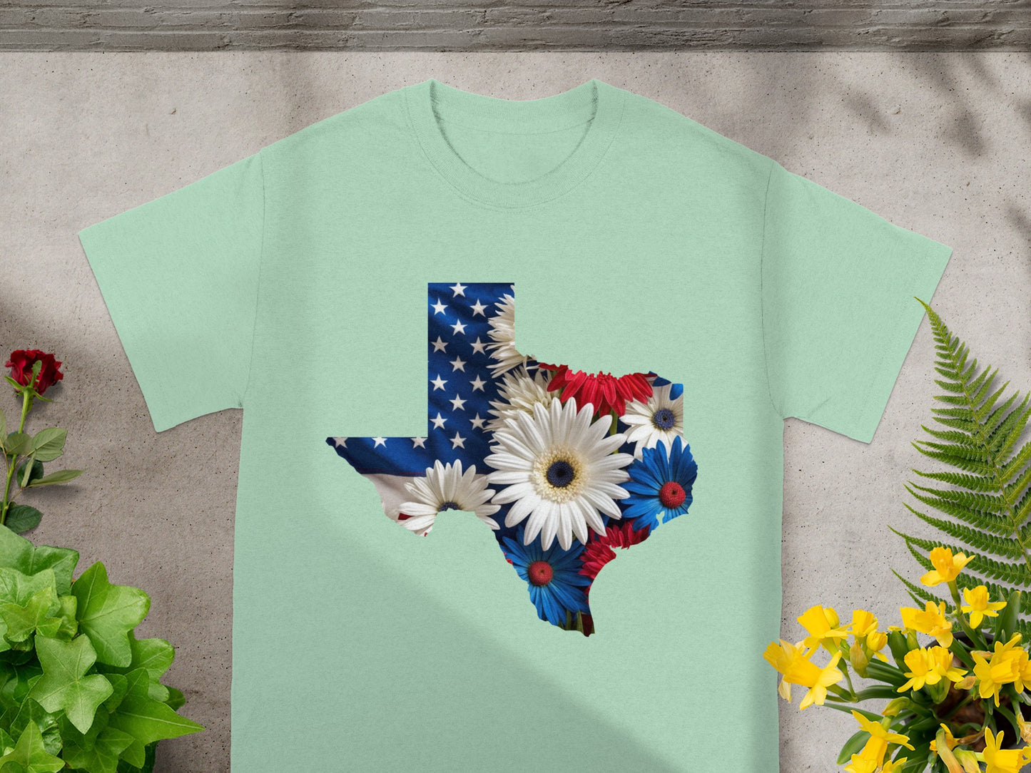 Light green t-shirt with Texas outline filled with American flag and flowers.