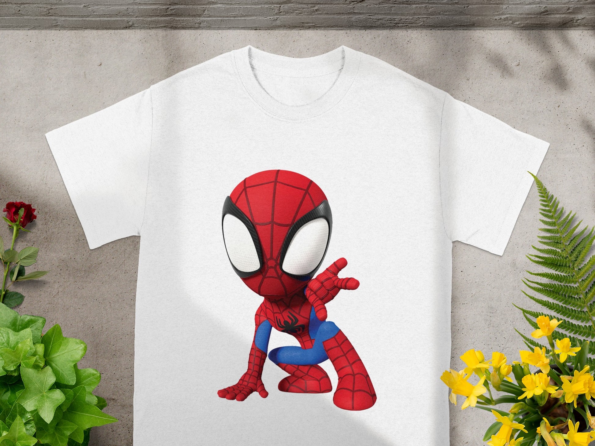 White t-shirt with cartoon Spiderman graphic in crouching pose.