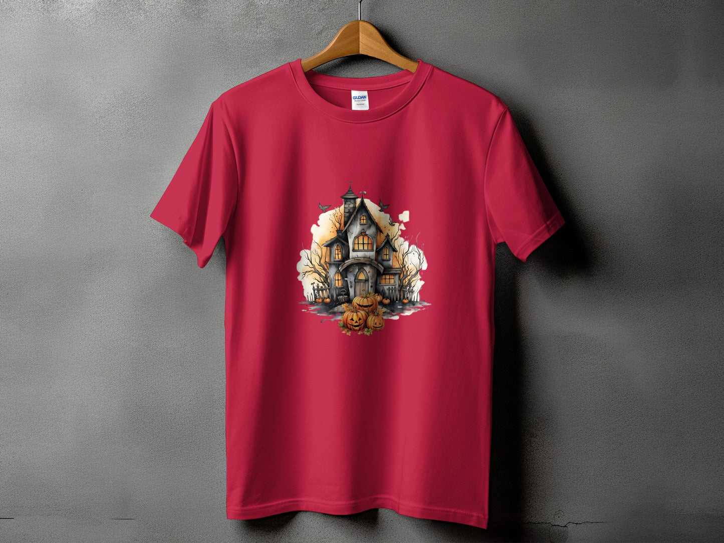 Red t-shirt with a watercolor print of a haunted house and pumpkins.