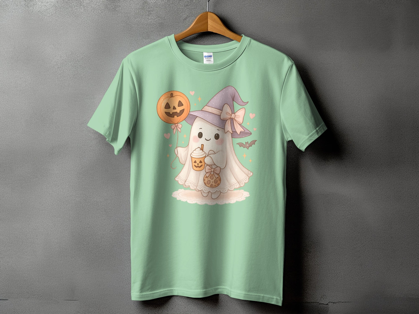 Ghost with Halloween balloon and pumpkin drink on mint t-shirt.
