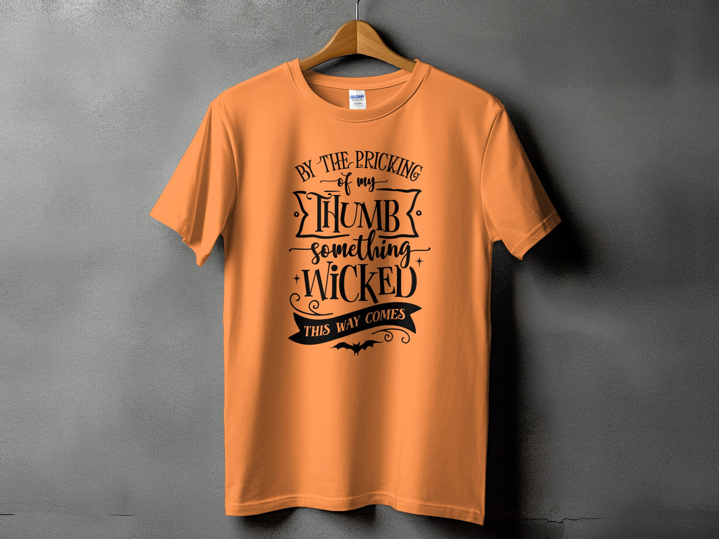 Orange t-shirt with "By the pricking of my thumb, something wicked this way comes" text.