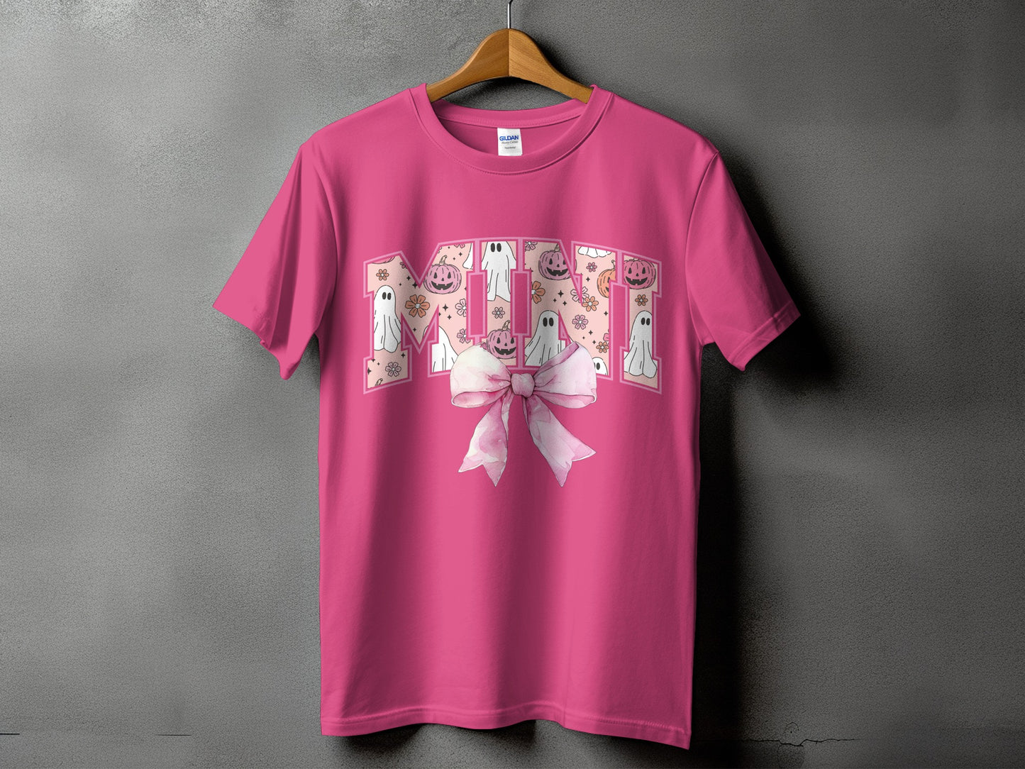 Pink t-shirt with "MINI" text featuring ghosts, pumpkins, and flowers.
