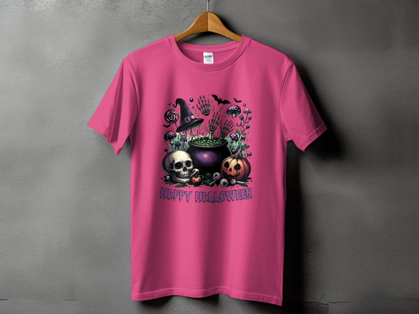 Pink t-shirt with a Halloween design featuring a cauldron, skull, pumpkin, and text.
