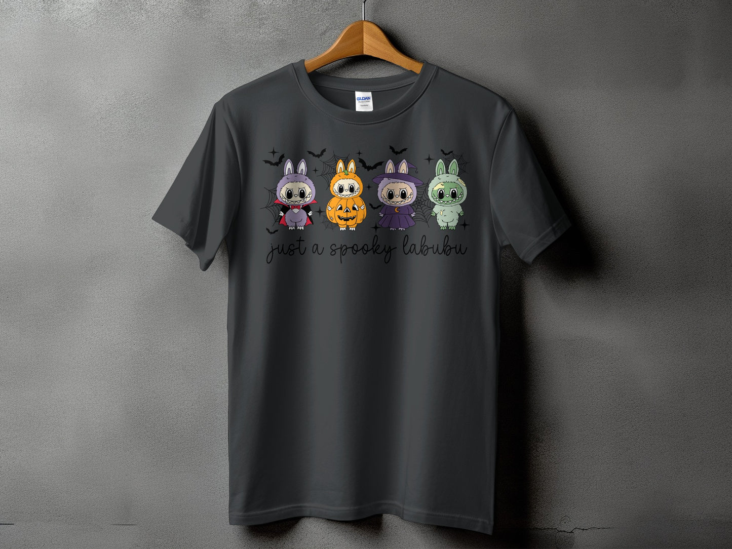 Dark grey t-shirt with four Halloween-themed cartoon labubus and "just a spooky labubu" text.