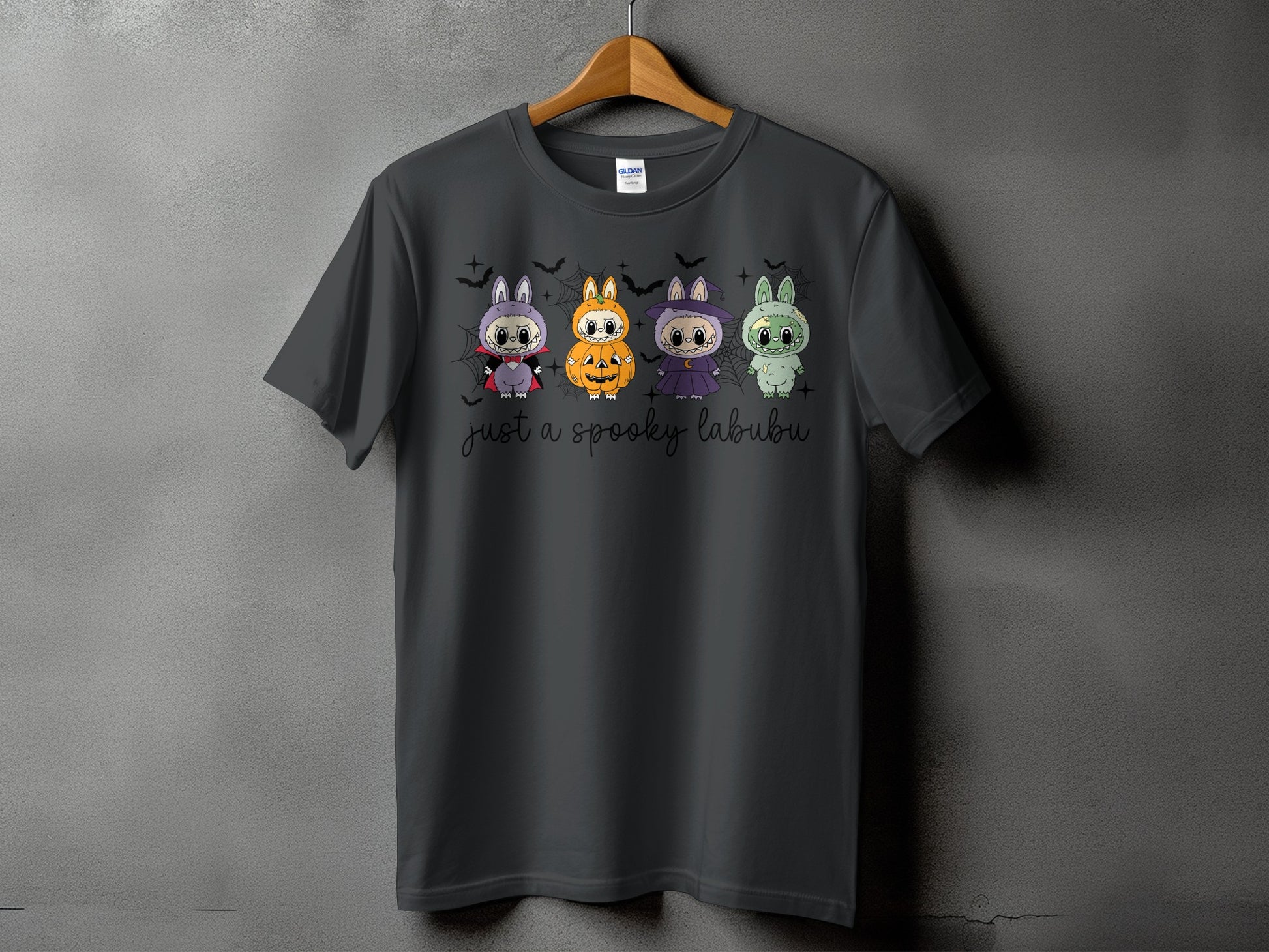 Dark grey t-shirt with four Halloween-themed cartoon labubus and "just a spooky labubu" text.