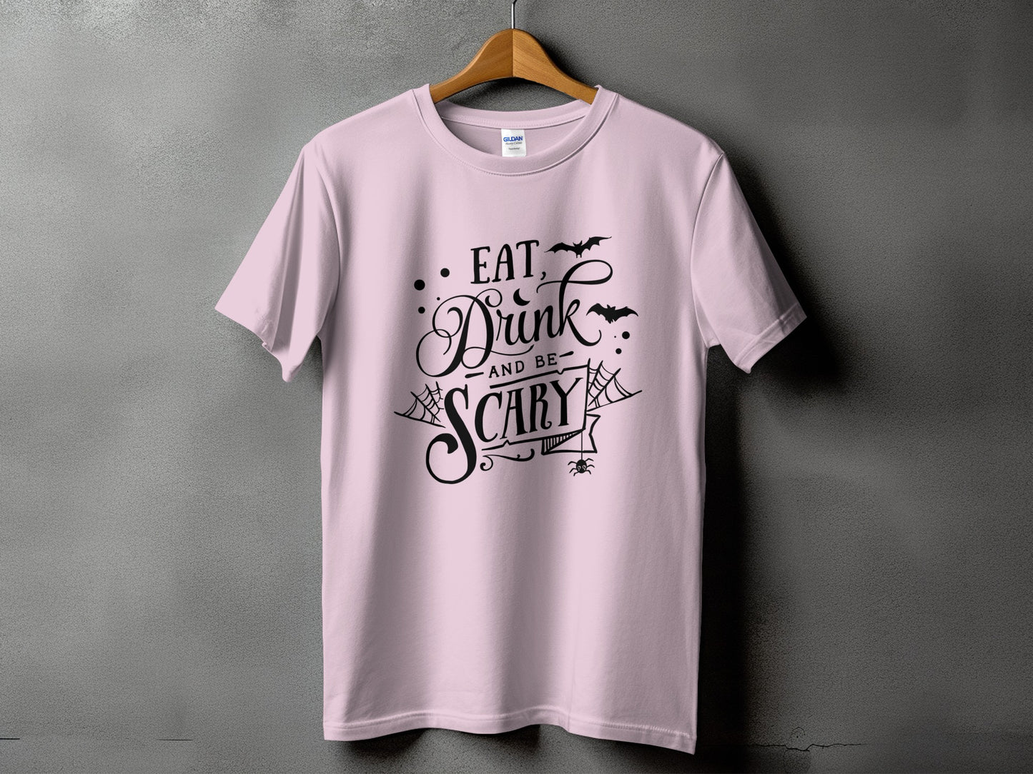 Light pink t-shirt with black Halloween text: "Eat, Drink and be Scary"