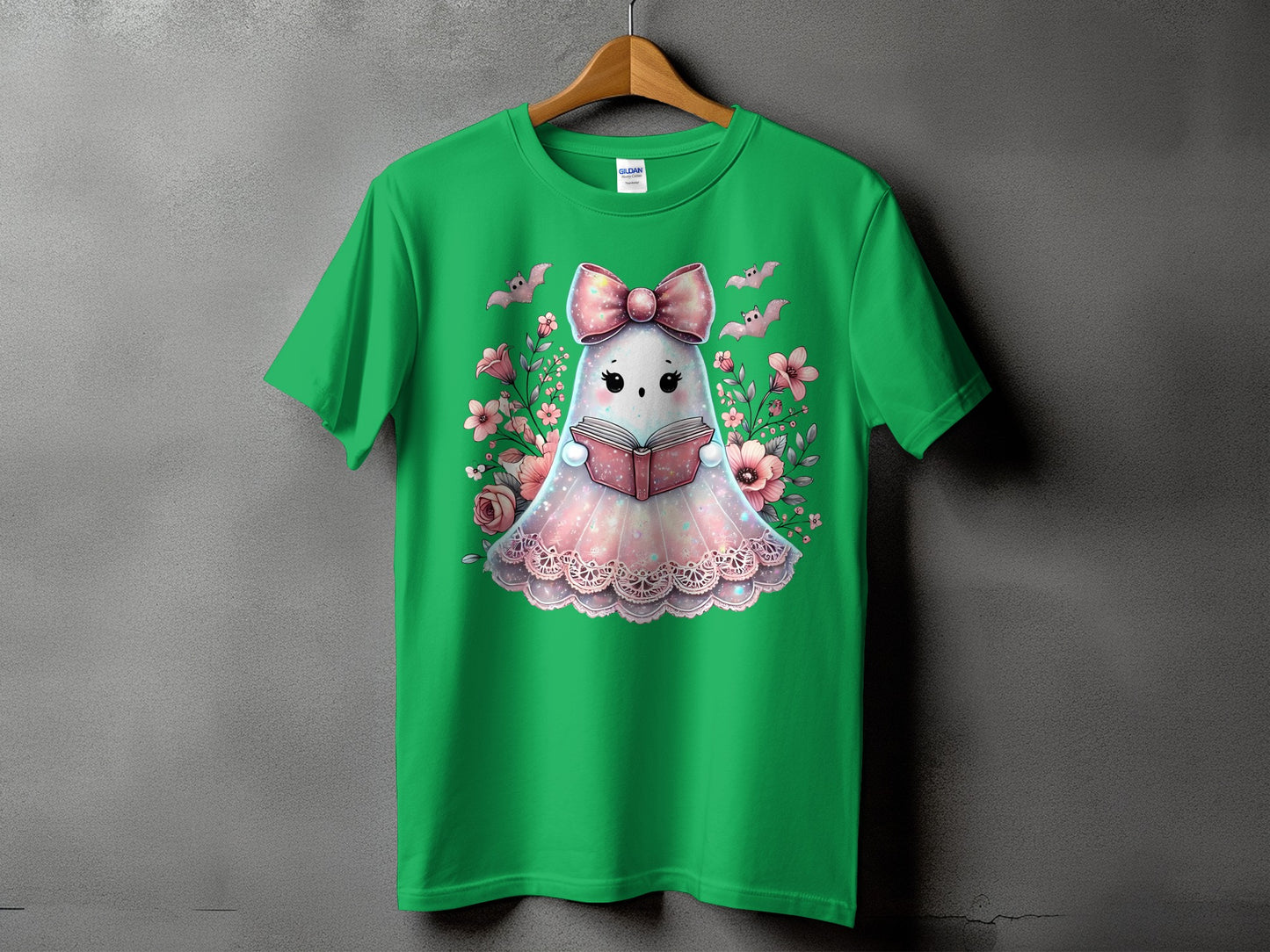 Green t-shirt with a cute ghost reading a book and surrounded by flowers.