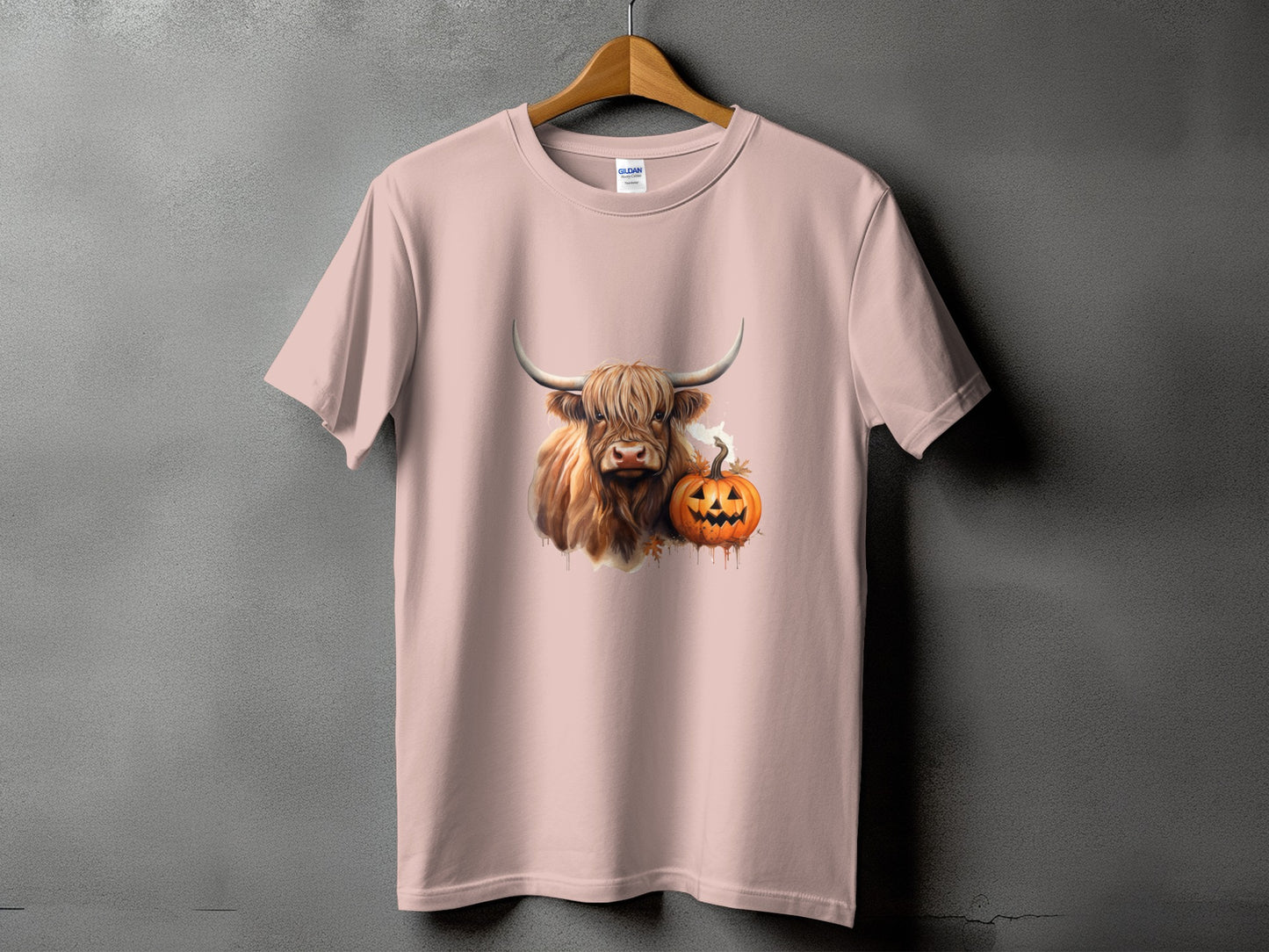 Light pink t-shirt with a Highland cow and a Jack-o'-lantern graphic.