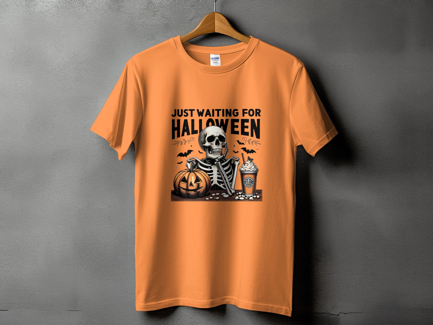 Orange t-shirt with skeleton, pumpkin, coffee cup, and bats graphic.