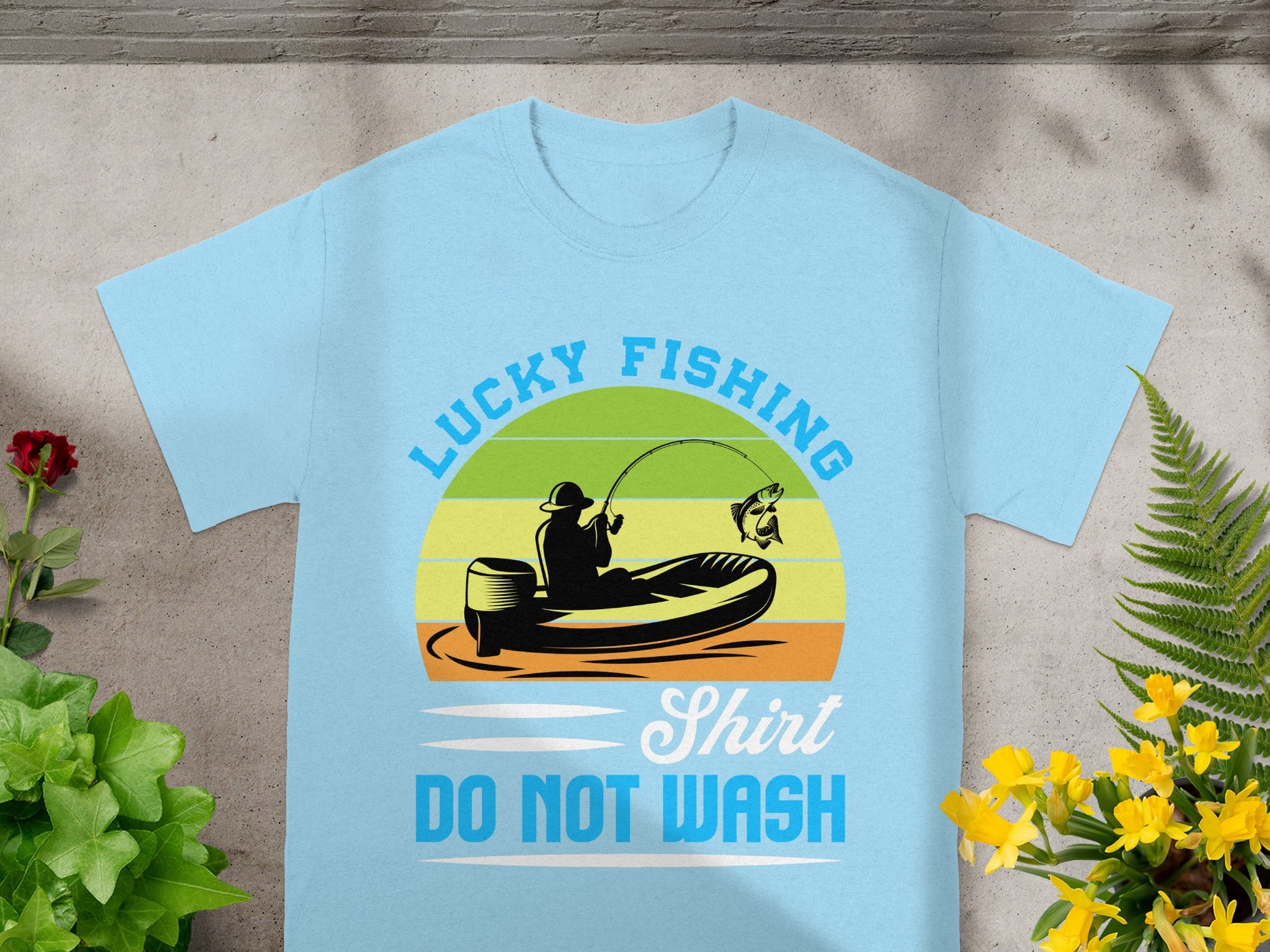 Light blue t-shirt with graphic of person fishing from a boat, reading "Lucky Fishing Shirt DO NOT WASH".