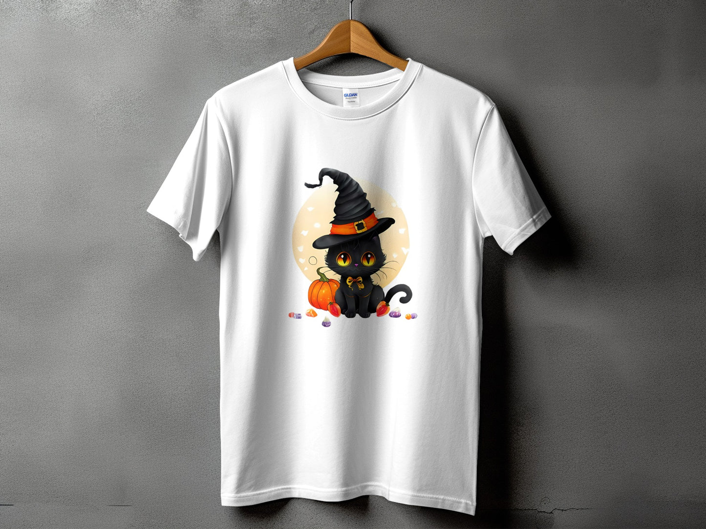 White t-shirt with a black cat wearing a witch hat and sitting next to a pumpkin.