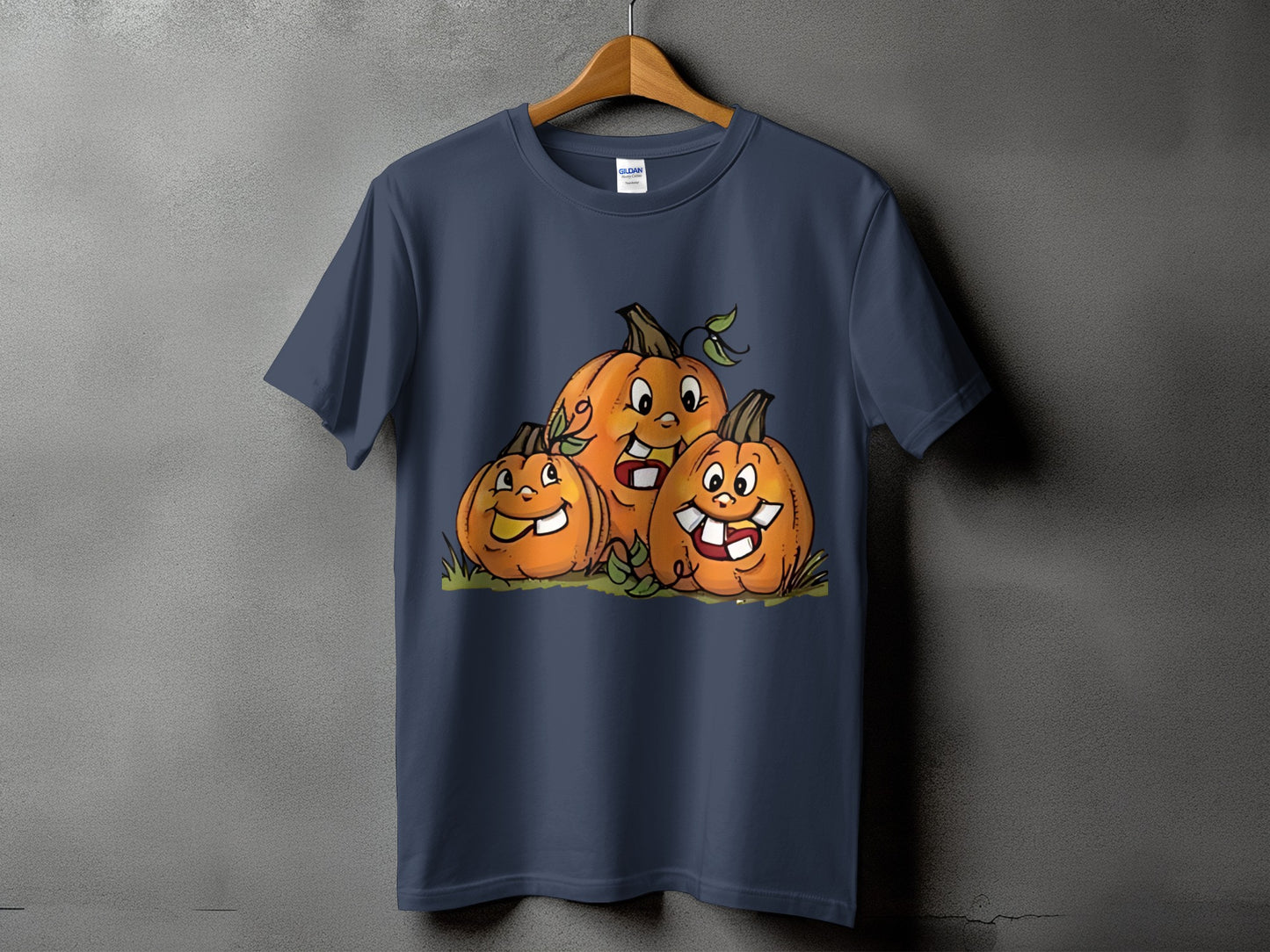 Three cartoon pumpkins with happy faces on a dark blue t-shirt.