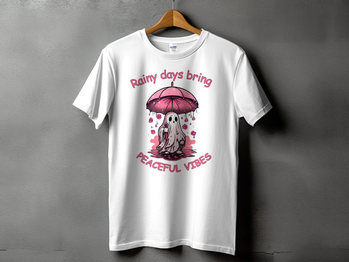 White t-shirt with a ghost under an umbrella and text "Rainy days bring peaceful vibes."