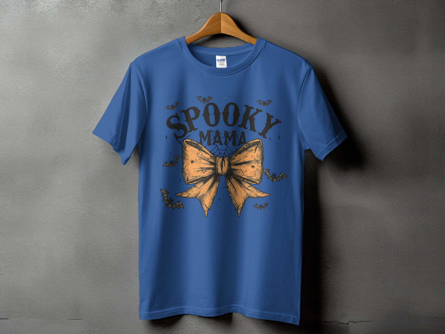 Blue t-shirt with "Spooky Mama" text, bow, and bats graphic.
