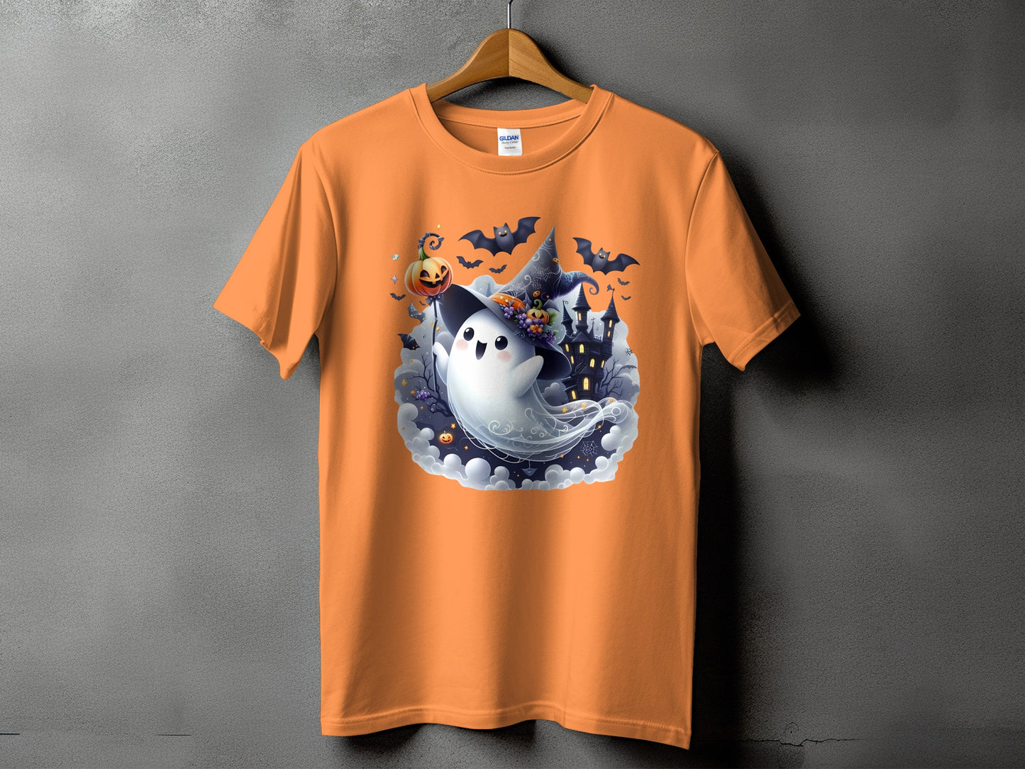 Orange t-shirt with a cartoon ghost, witch hat, pumpkin, bats, and haunted house design.