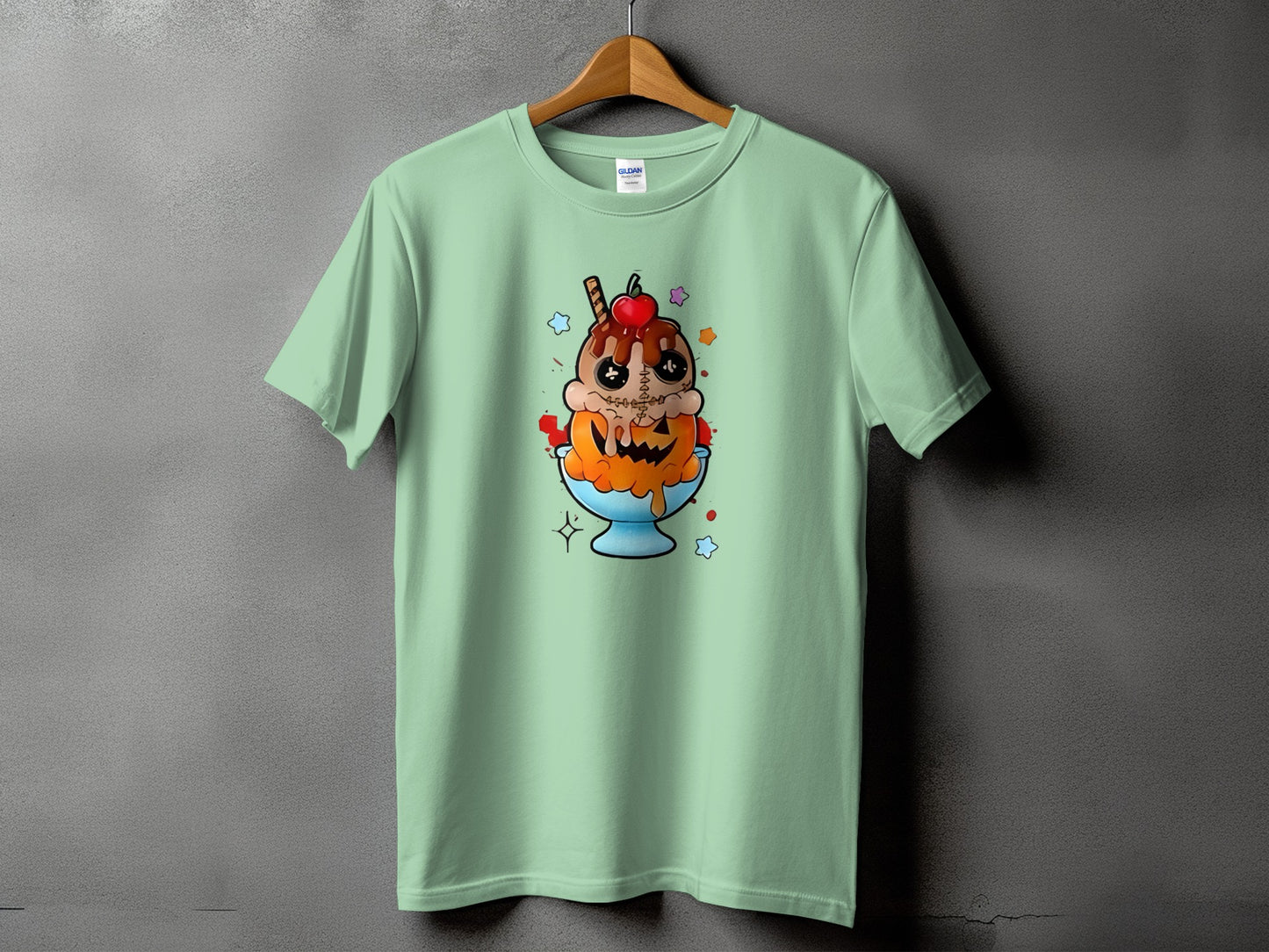 Green t-shirt with a spooky ice cream sundae graphic featuring a pumpkin and stitched details.