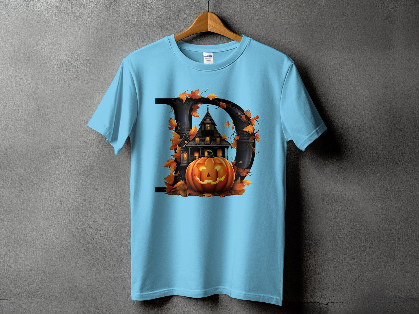 Light blue t-shirt featuring a black letter D with a haunted house and pumpkin design.