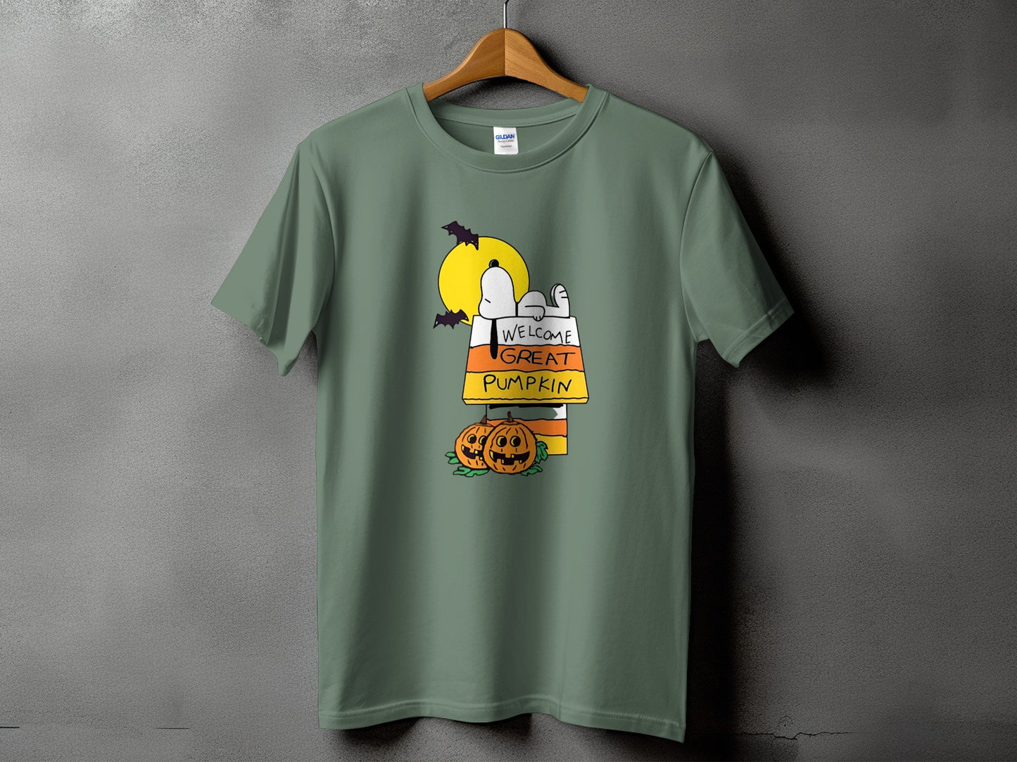Green t-shirt with Snoopy on a candy corn welcome sign and pumpkins.