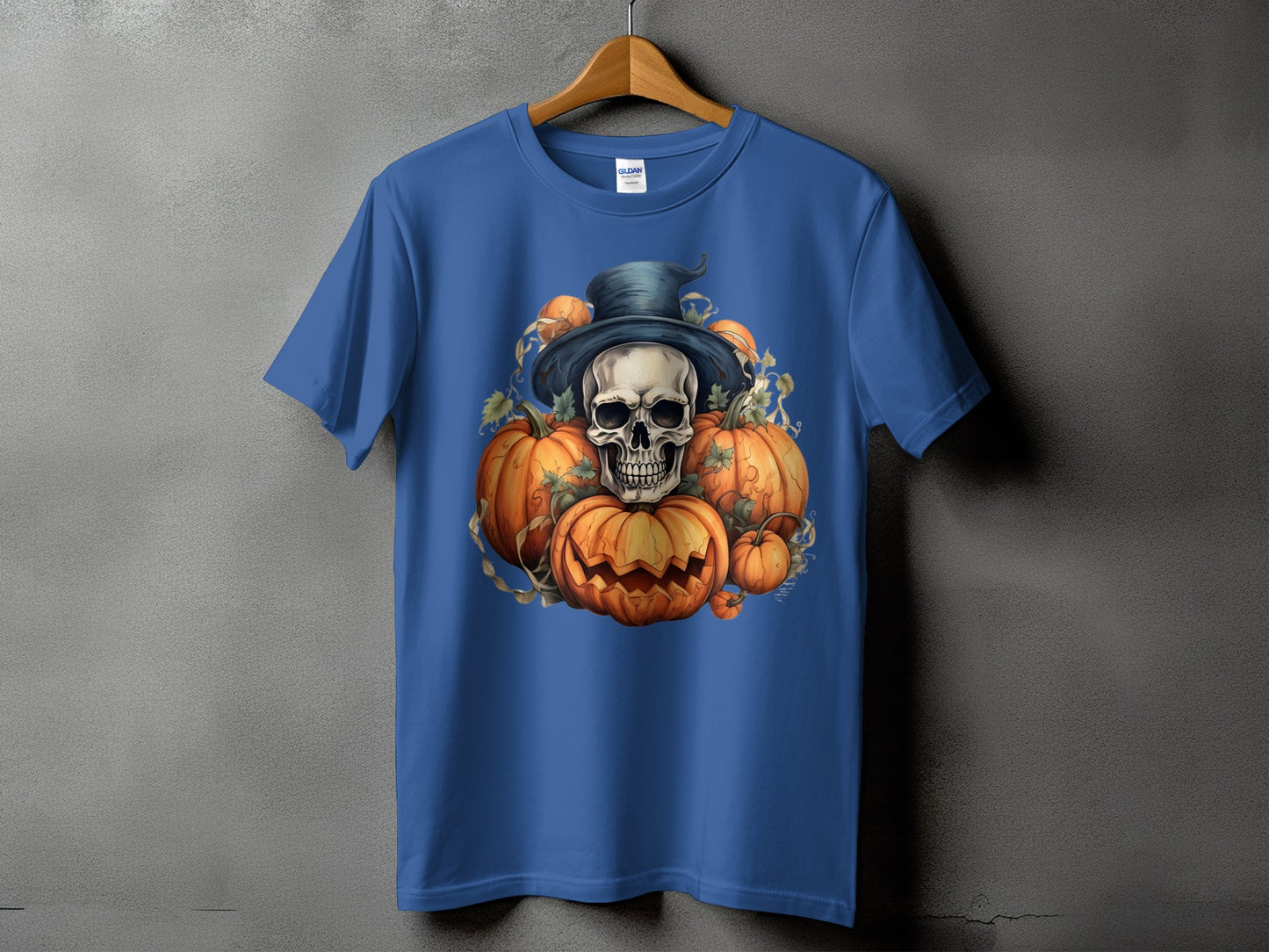 Blue t-shirt with a Halloween graphic of a skull wearing a hat surrounded by pumpkins.