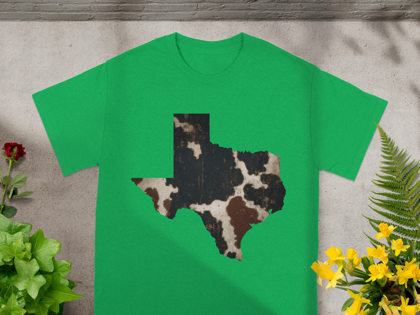Green t-shirt with a Texas outline graphic in cow print.