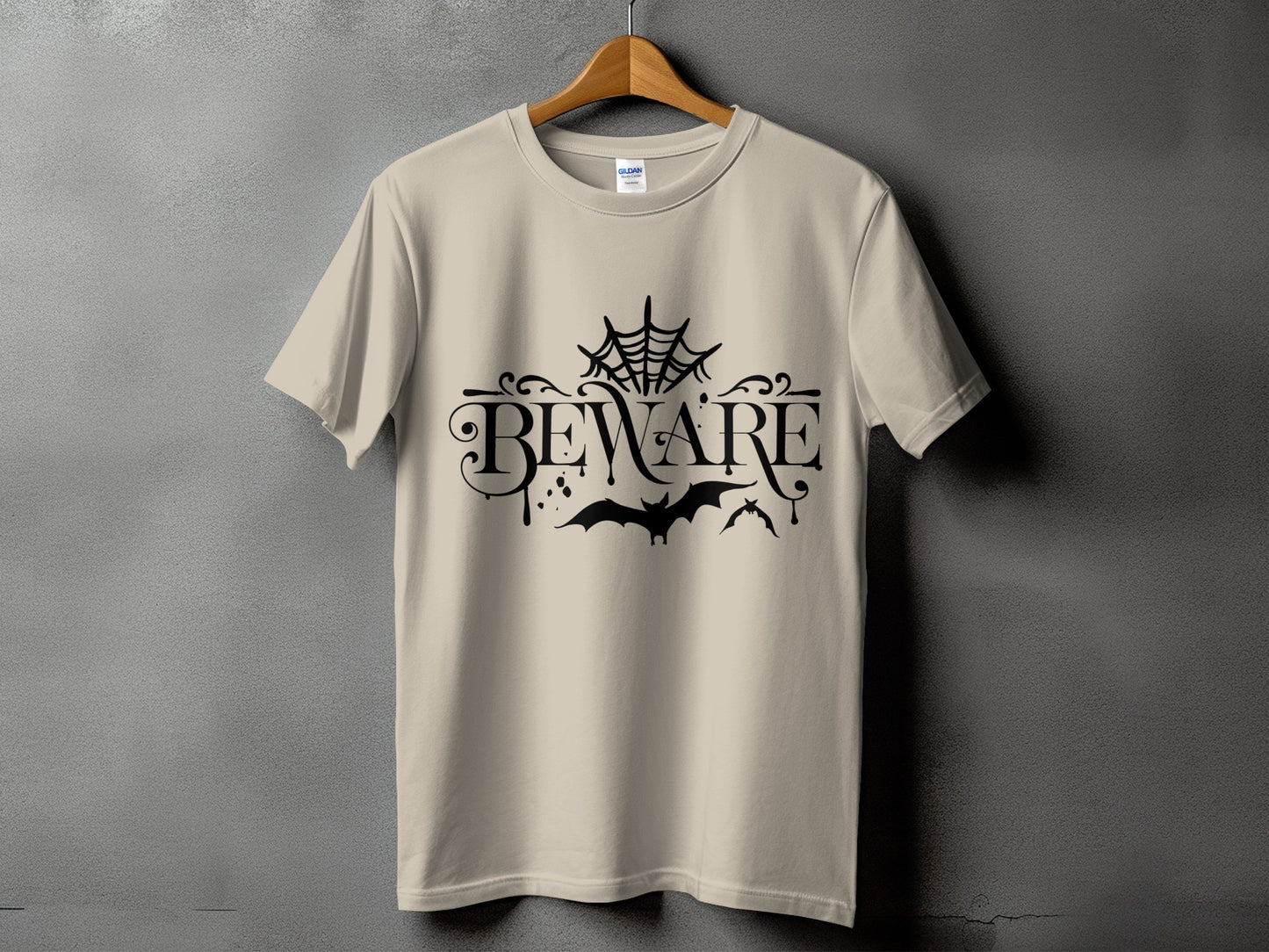 Tan t-shirt with black "BEWARE" text, spiderweb, and bats graphic.