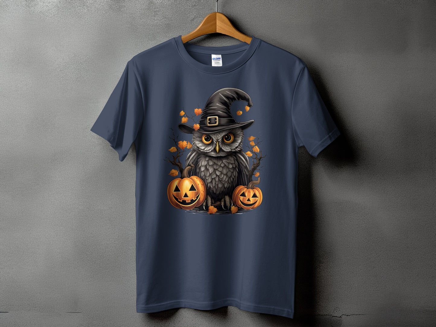 Owl in witch hat with pumpkins and autumn leaves graphic on navy t-shirt.