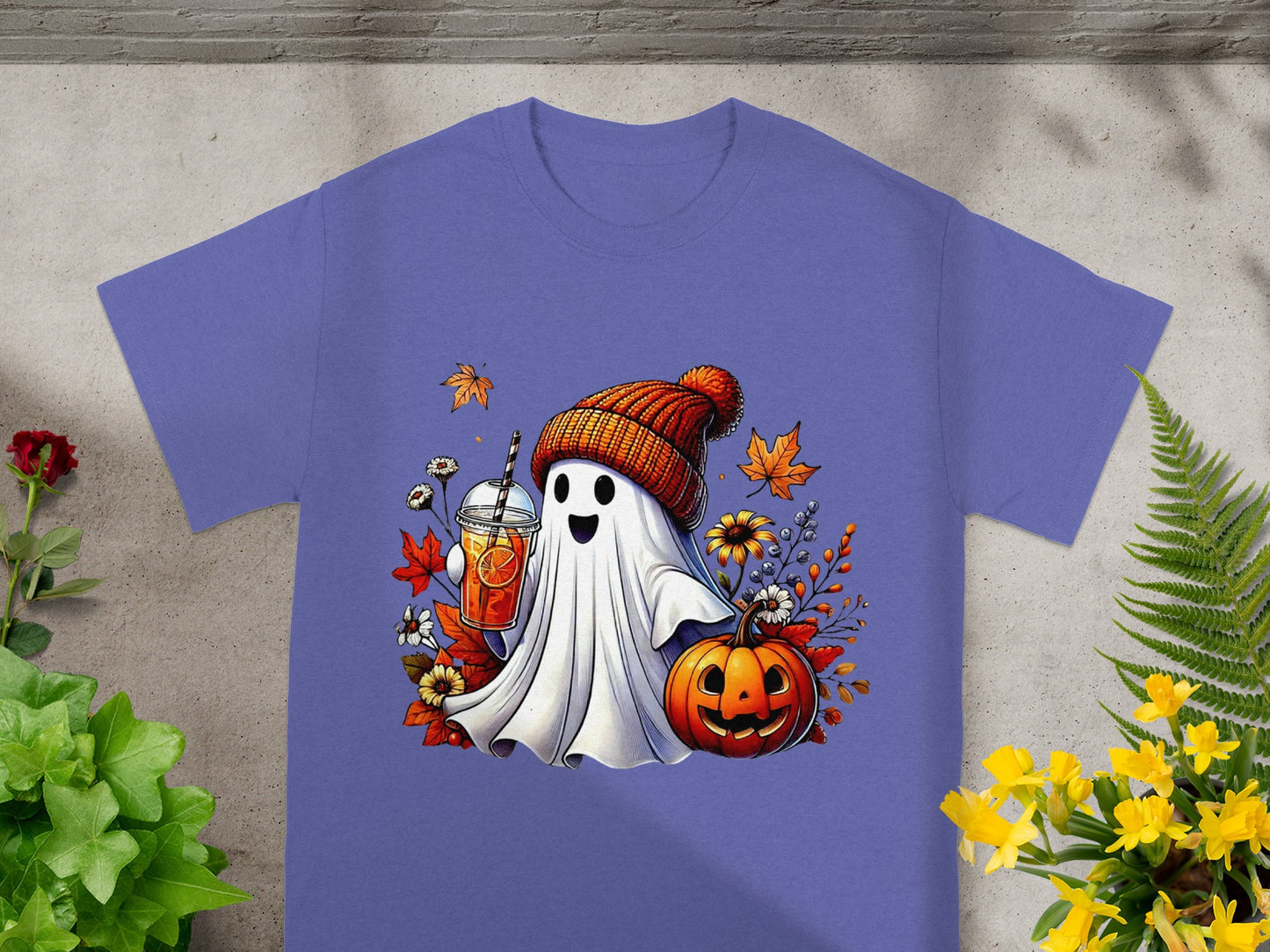 Ghost wearing hat holds drink by jack-o'-lantern with fall leaves and flowers.