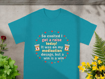 Teal t-shirt with text about a raise and medication dosage.