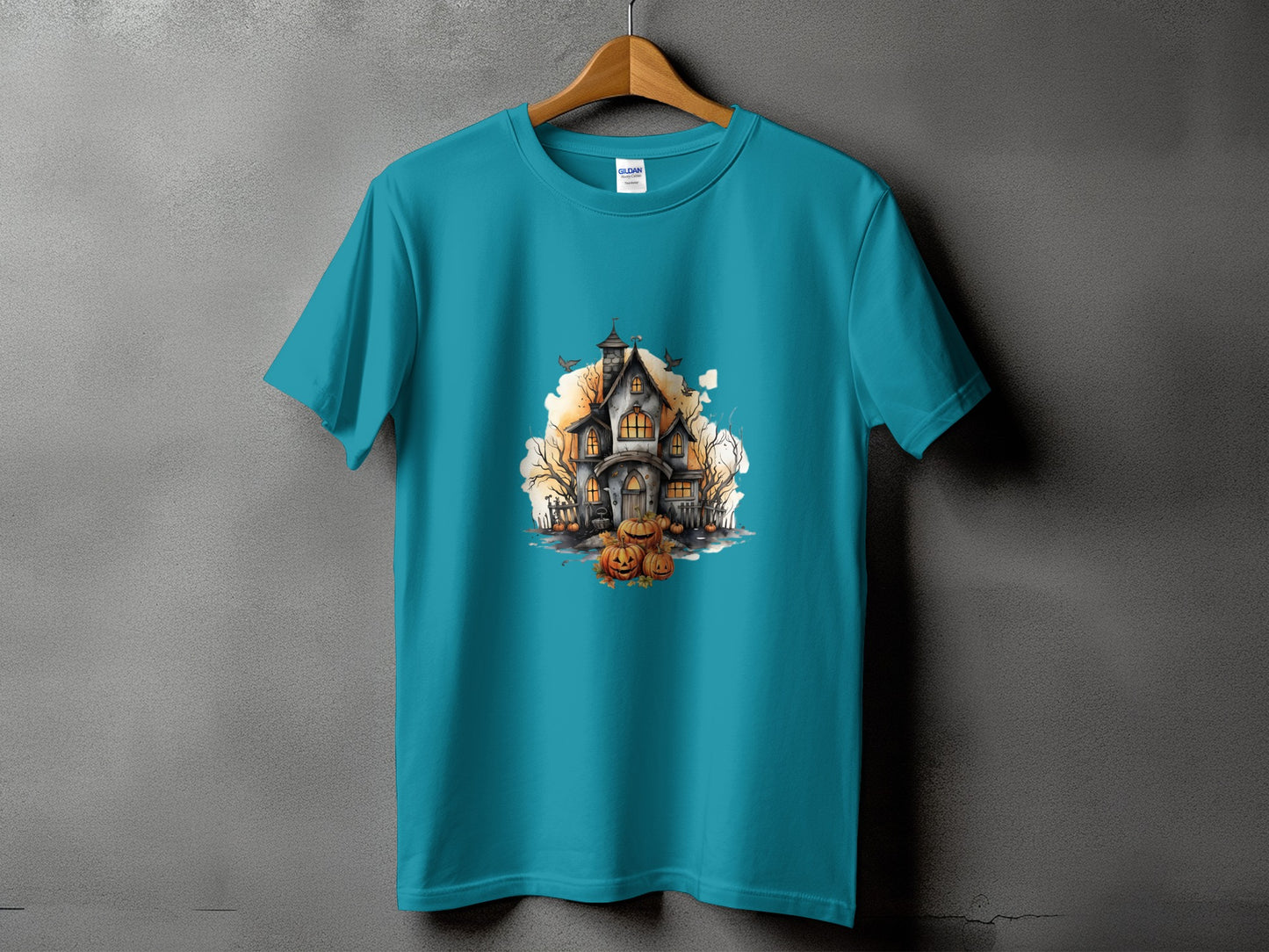 Teal t-shirt with a Halloween haunted house and pumpkins graphic.