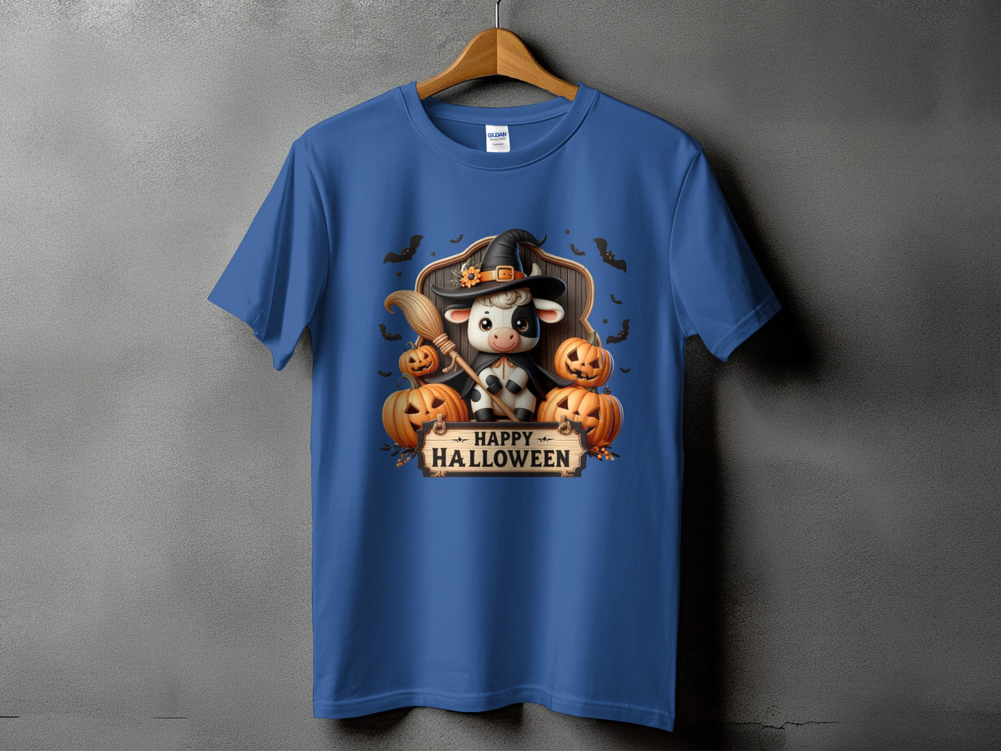 T-shirt with Halloween graphic featuring a cow in a witch hat, pumpkins, and bats.